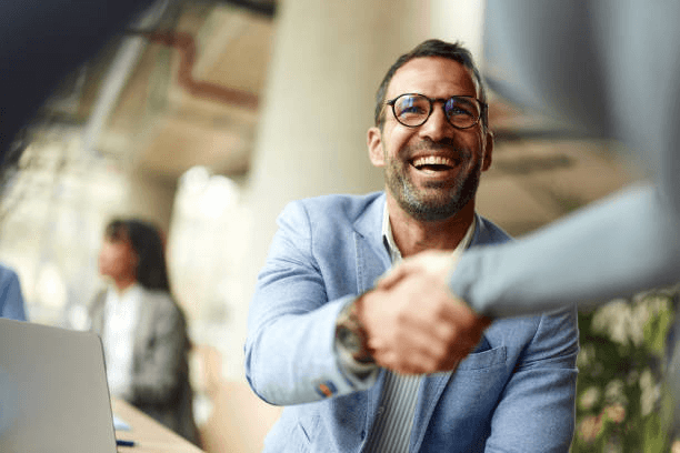 A Commtrac representative shaking hands with a client after a meeting