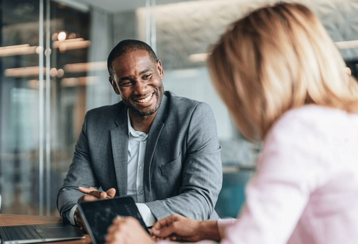 Two bankers reviewing clearing terms together at a meeting table